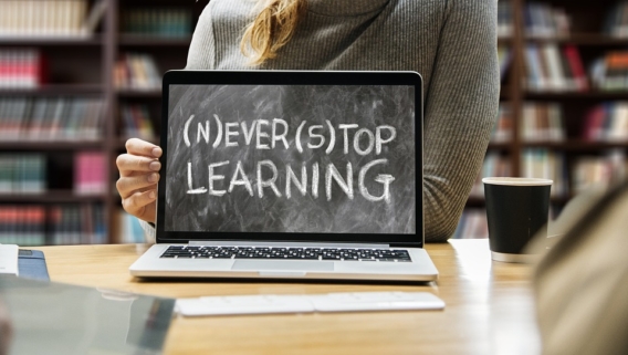 Az asztalon egy laptop, amelynek kijelzője klasszikus táblaként fest, ráírva: never stop learning, vagyis soha ne hagyd abba a tanulást.