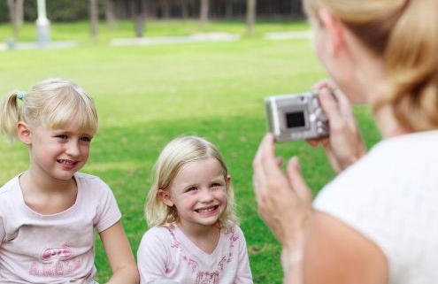 Egy nő fotót készít két kisgyermekről