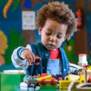 Idegen anyanyelvű gyermekek helyzete a bölcsődében Egy afro frizurás kisfiú játszik a bölcsődében fajátékokkal