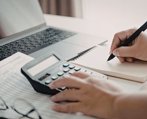 A szolgáltatási önköltség megállapítása április 1-jéig - a kiemelt képen egy női kéz számológéppel kalkulál, a hölgy jobb kezében van egy toll és jegyzetel