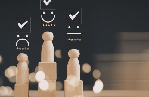 Részmunkaidős munkavállaló teljesítményértékelése - a képen fabábukat láthatunk fakockákon, a "fejük" felett az értékelést jelző csillagok, és az értékelésnek megfelelő smiley