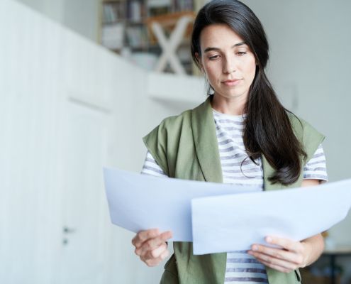 BTMN jogi előírások a szabályzatokban kiemelt képen egy nő dokumentumokat olvas